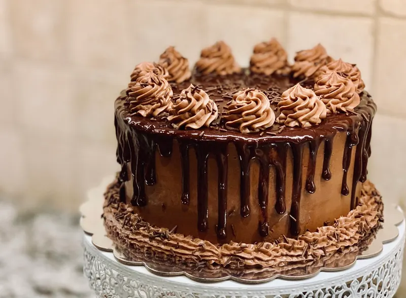 Gâteau à étages décoré posé sur une surface blanche, touche pâtissière artisanale.